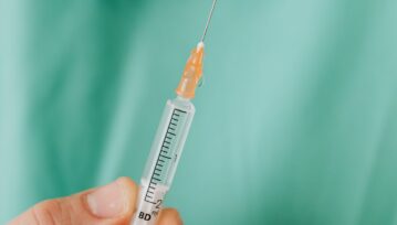 Close-up View Of Person Holding A Vaccine